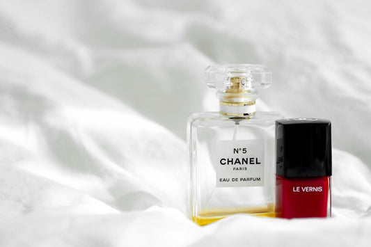 clear glass perfume bottle on white textile
