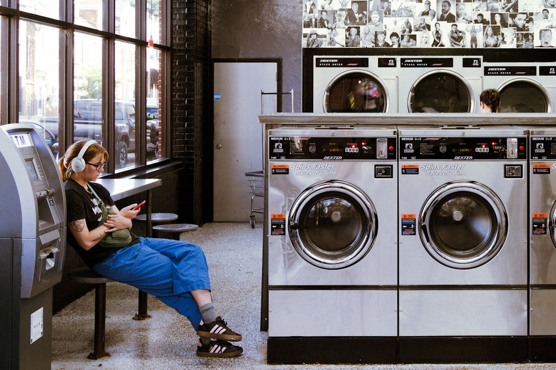 A woman sitting on a bench next to a stack of washers